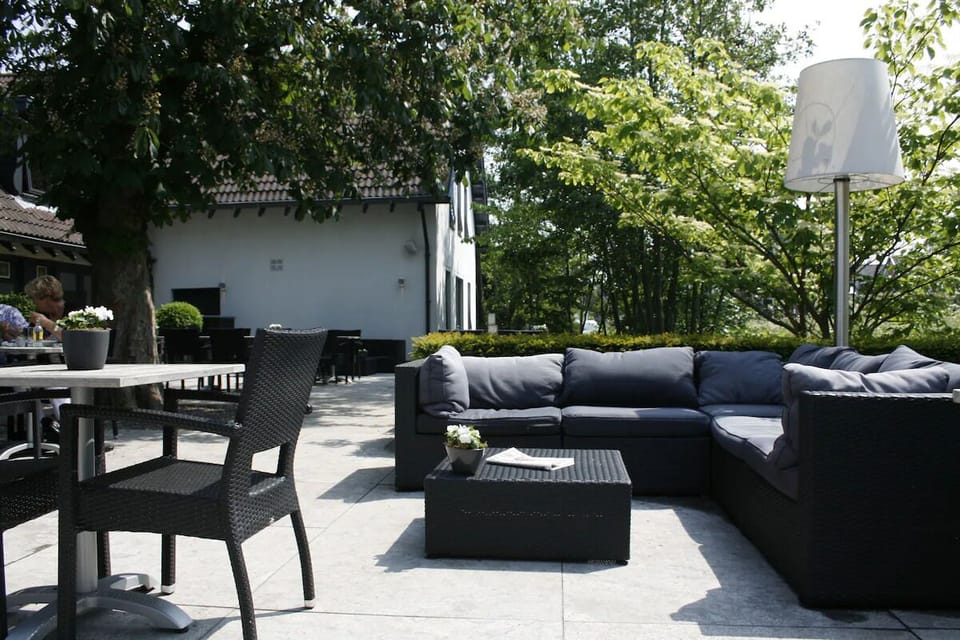 Lounge outdoors beneath leafy shade with comfortable seating areas.