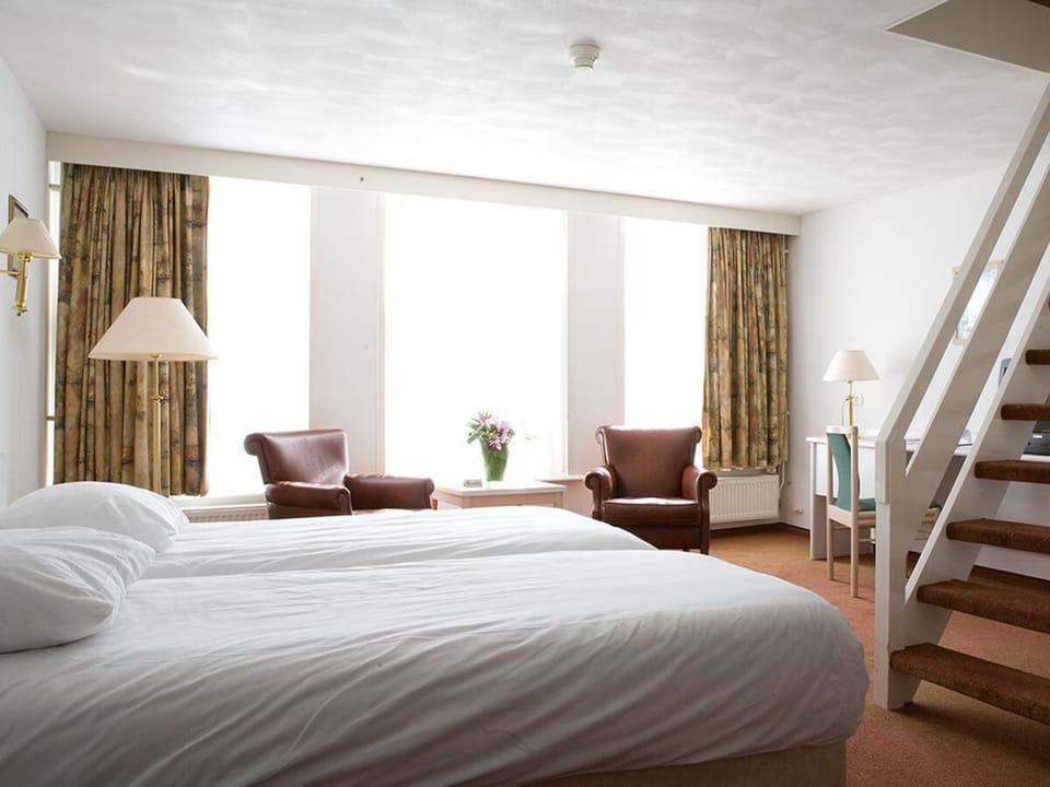 Stretch out in a sunlit bedroom with lounge seating.