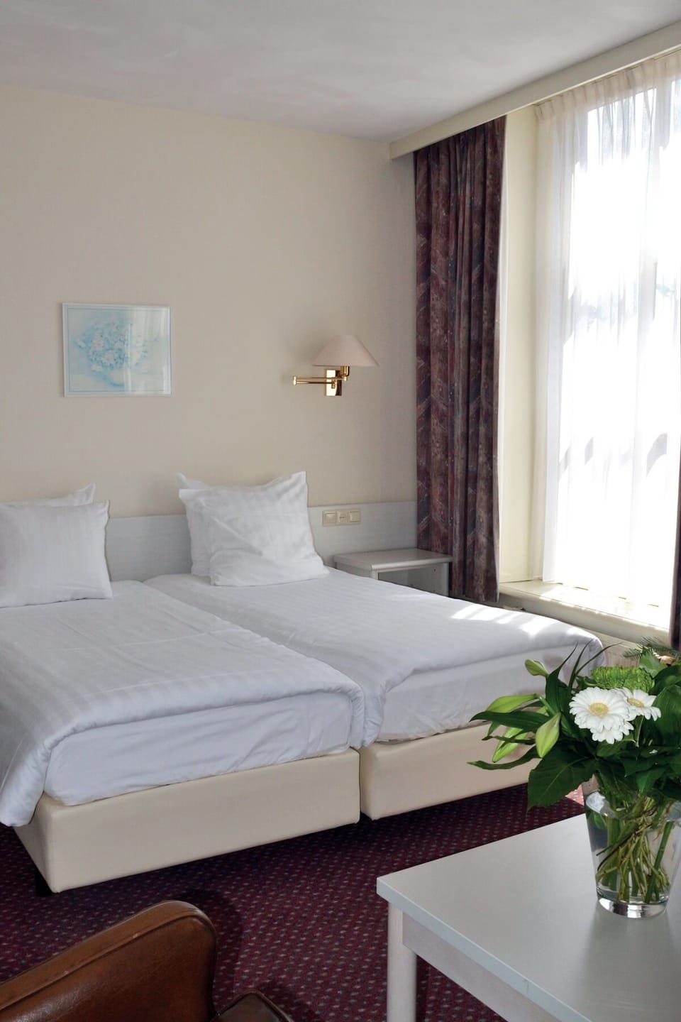 Drift off on comfortable twin beds beside glowing natural light.