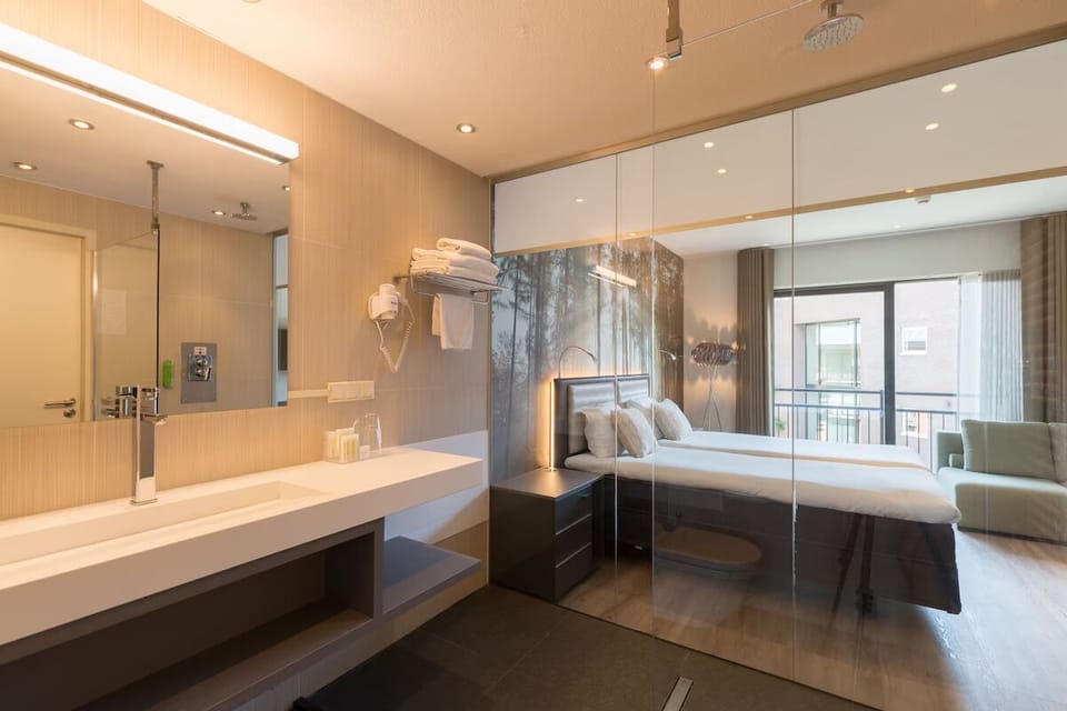 Refresh under warm lighting with sleek vanity and rainfall shower.