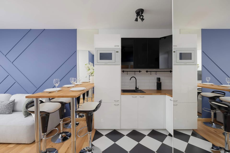 A dining area next to a compact kitchenette with modern finishes.