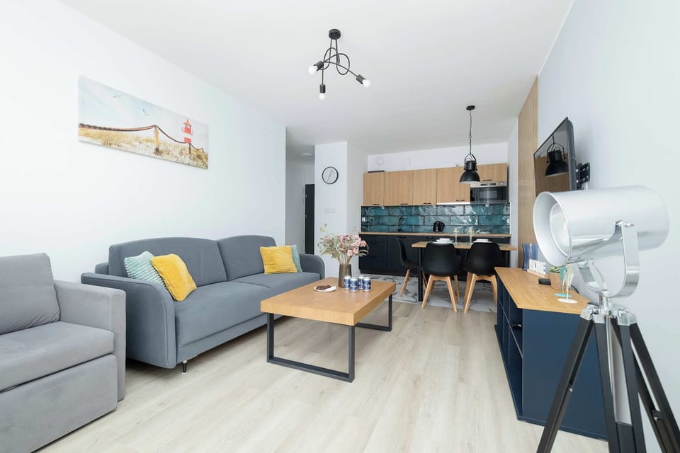 A wide-angle view of the living area reveals an open-plan layout connecting the lounge, dining zone, and kitchen.