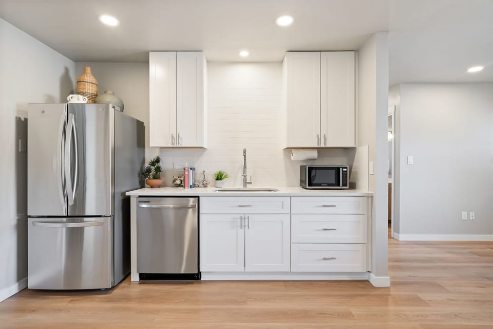 Your fully equipped modern kitchen features stainless steel appliances, pristine white cabinetry, and everything you need to prepare delicious meals during your stay.