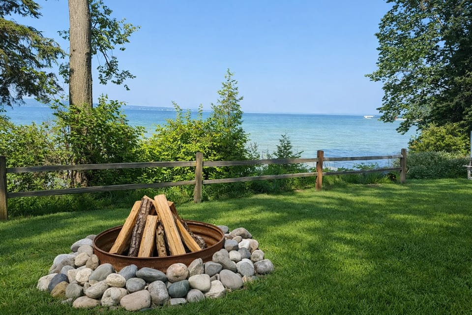 Cozy fire pit with peaceful waterfront views of Burt Lake.