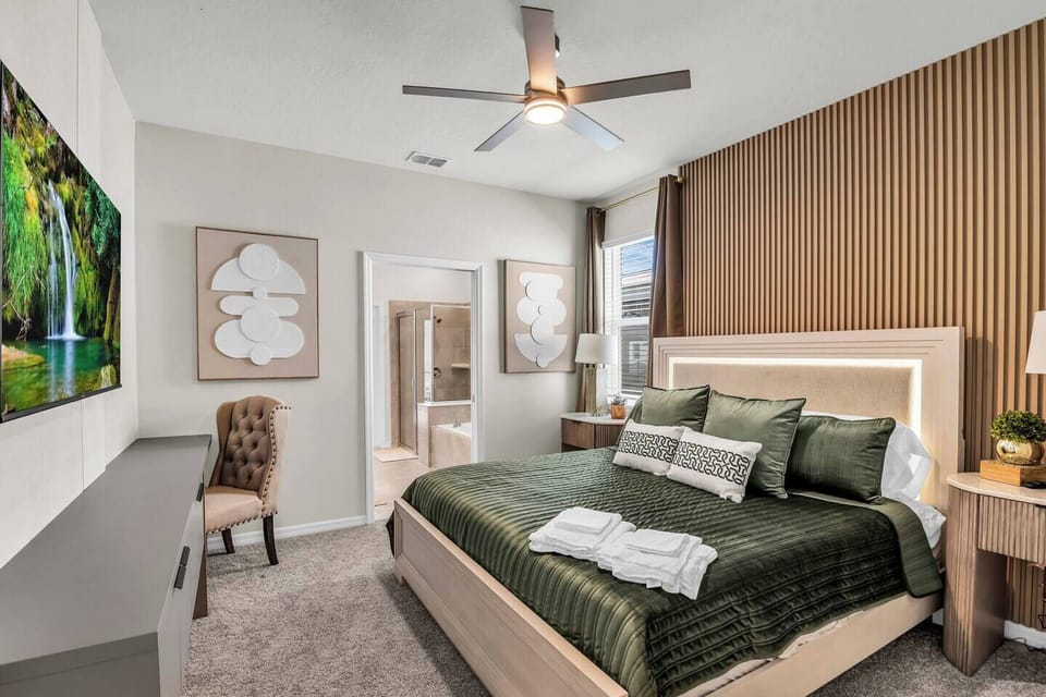 Restful bedroom w/ bed dressed in soothing olive tones for a peaceful night`s sleep.