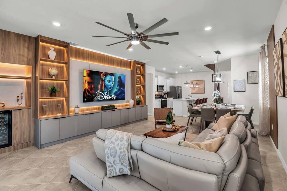 Comfy living room w/ plush sectional, mounted TV & ceiling fan for easy lounging.