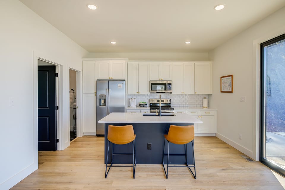 Open kitchen with island seating and stainless appliances