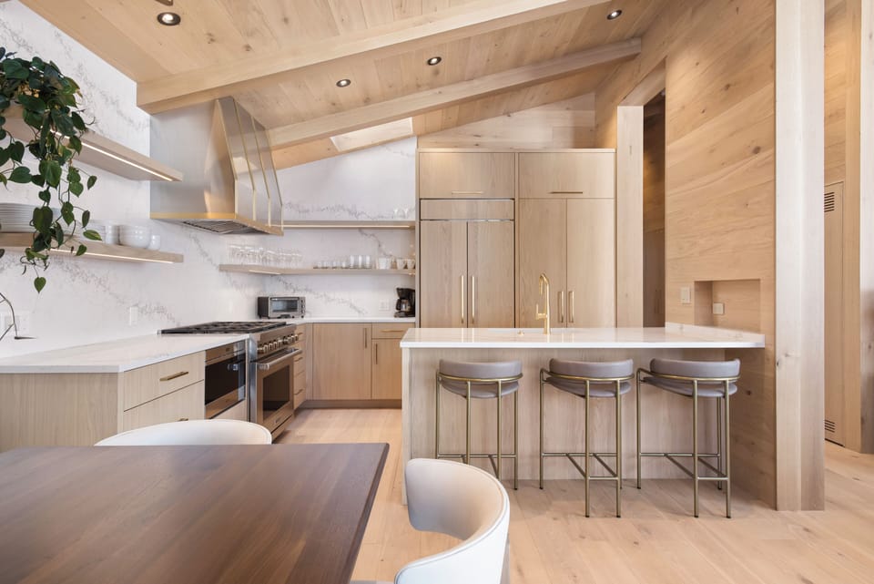 Fully equipped kitchen with natural stone countertops, custom cabinetry, and high-end appliances including a Wolf Range.