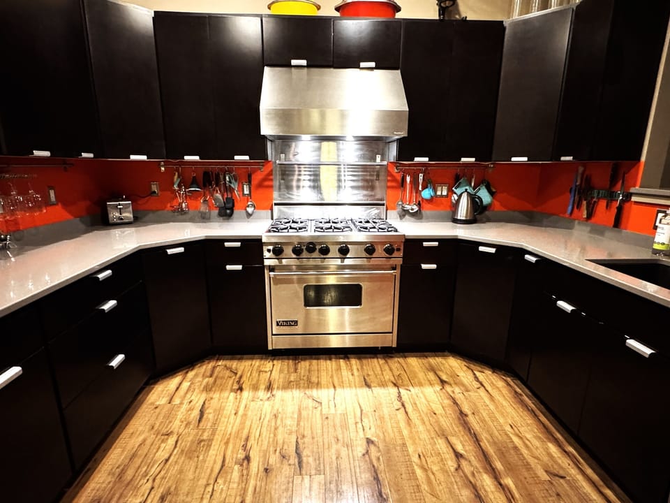 Fully equipped chef's kitchen featuring a professional-grade Viking range and expansive granite countertops. This modern space includes stainless steel appliances and full inventory for easy meal prep, making it a great home base for your group.