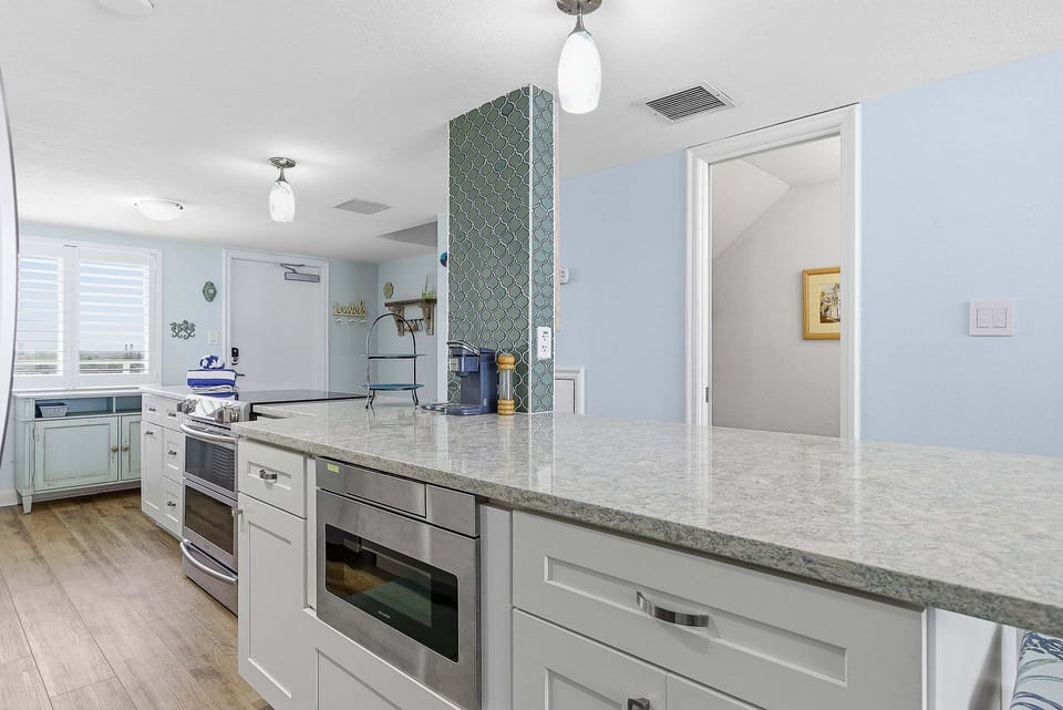 This beach stay offers a spacious open kitchen with a large island, modern appliances, and coastal design. Perfect for gathering, cooking, and enjoying easy, breezy meals after a day at the beach.