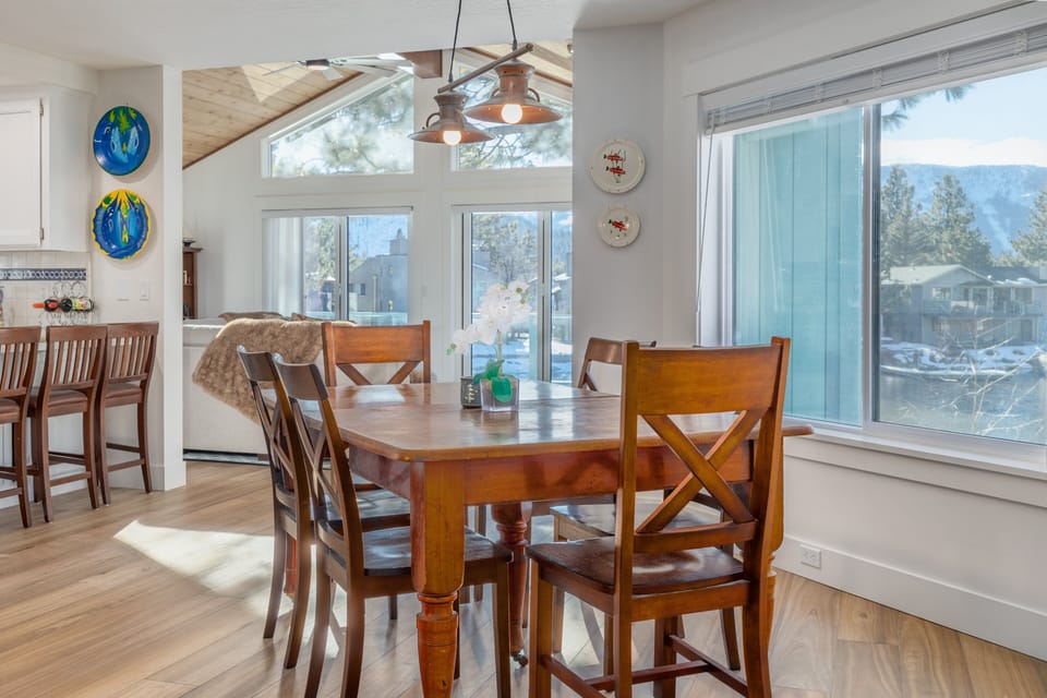 Dining area with seats, breakfast bar, large windows, canal view, and hanging lights.