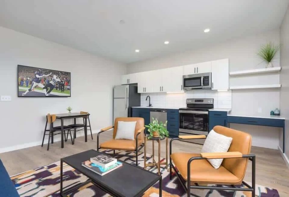 Bright and open living area featuring a smart TV, plush furnishings, and access to the private balcony. Connects to the dining area and kitchen.