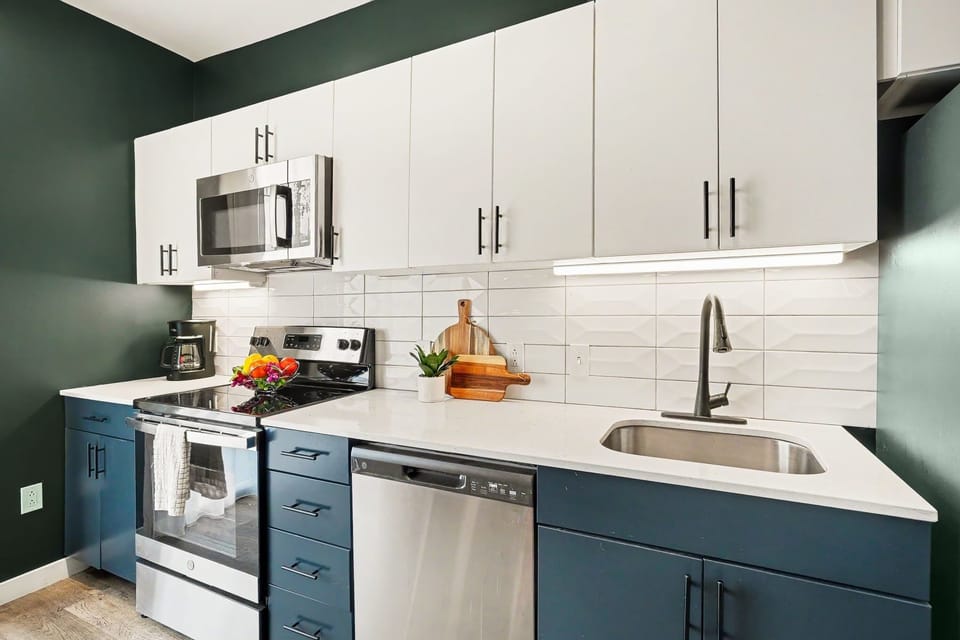 Fully equipped kitchen with stainless steel appliances, electric stove top, microwave, dishwasher, oven, and full size fridge.