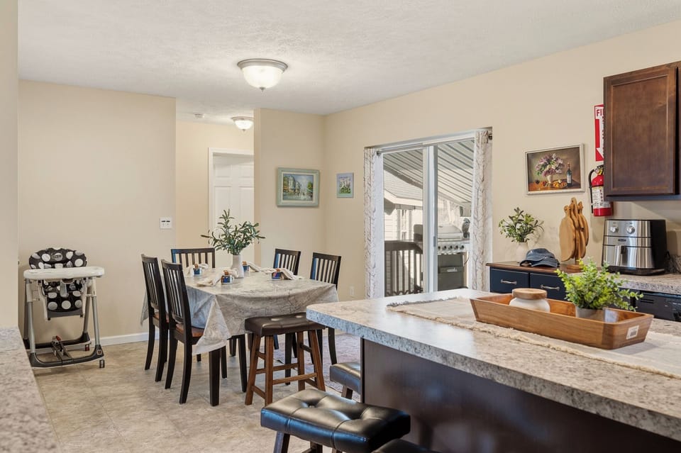Bright dining area with family‑friendly seating and an open kitchen that flows easily to the deck.