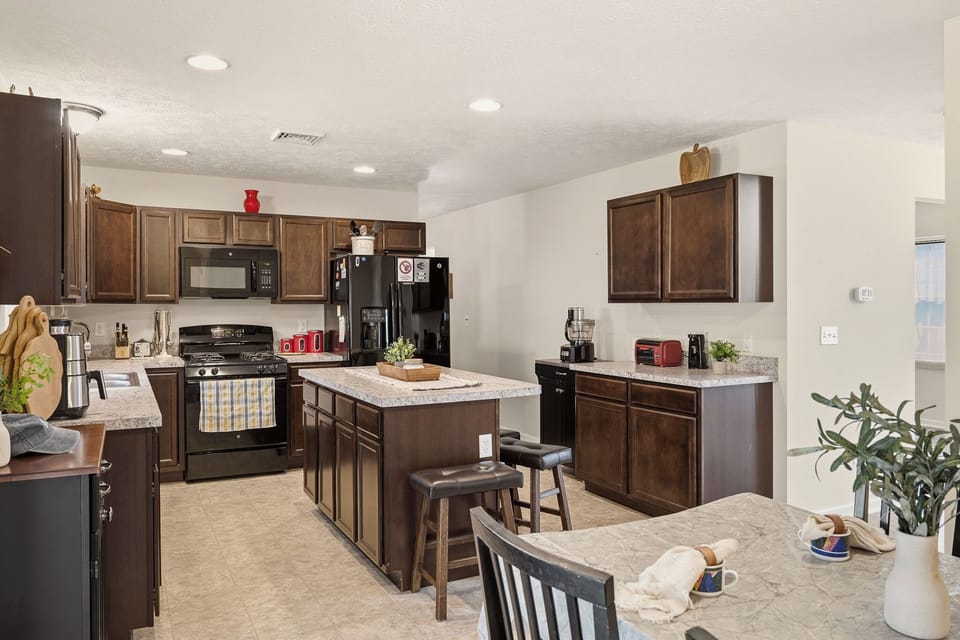 Cozy, well‑equipped kitchen with granite counters, stainless steel appliances, and a spacious island for gathering.