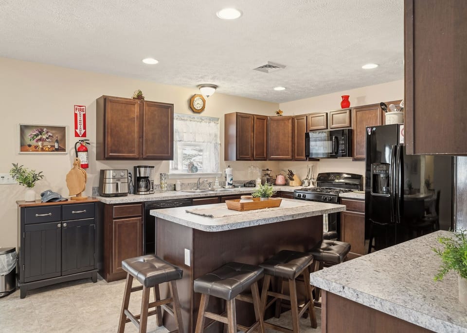 Cozy, well‑equipped kitchen with granite counters, stainless steel appliances, and a spacious island for gathering.