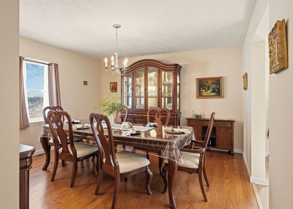 Elegant dining room with a classic wood table, chandelier lighting, and a beautifully curated china cabinet.