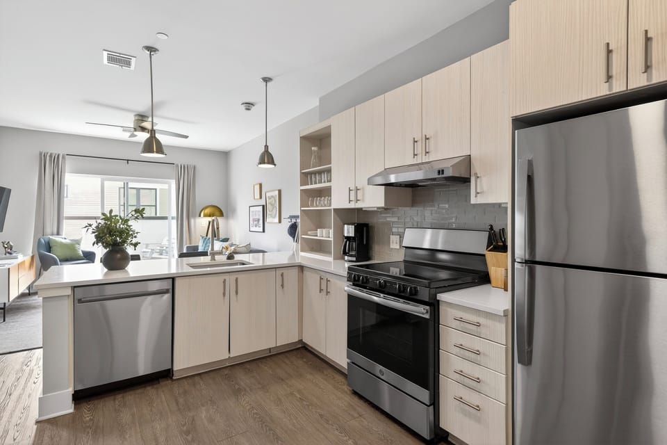 Modern kitchen featuring white cabinetry and stainless steel appliances.