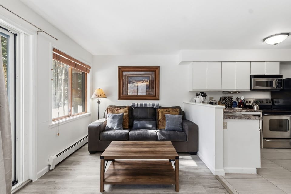 Your bright, open-plan living space blends comfort with convenience, featuring a cozy sofa and fully-equipped kitchen for memorable stays.