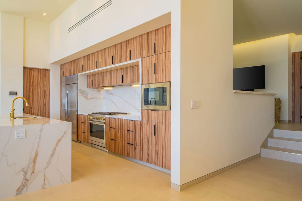 Your modern kitchen features sleek wood cabinetry, marble backsplash, and premium appliances for effortless cooking and entertaining.