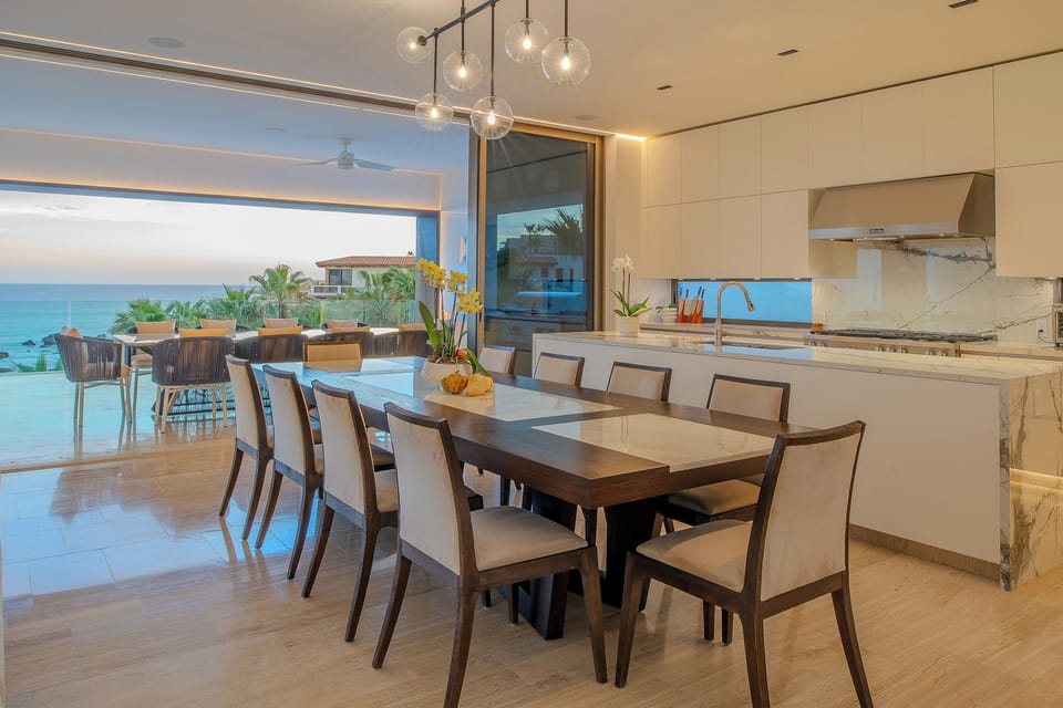 Your open-plan kitchen flows seamlessly to ocean views, where warm lighting and marble counters create the perfect space for memorable meals.