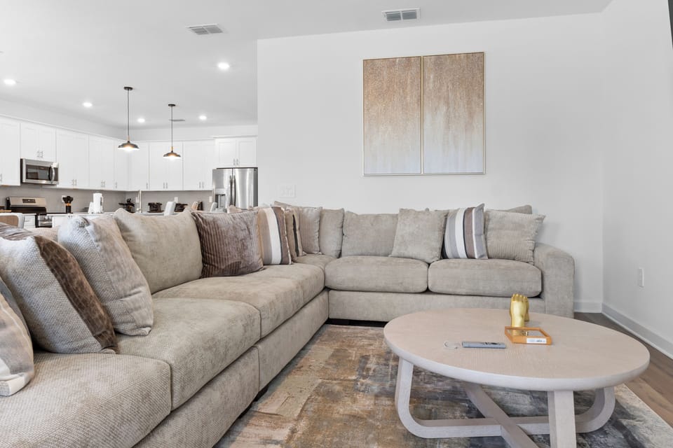Sink into the plush sectional sofa where you'll unwind after exploring, with the modern kitchen ready for your morning coffee.
