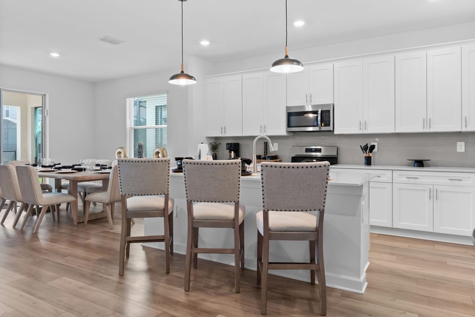 Your open-concept kitchen and dining space features sleek white cabinetry, granite counters, and stylish pendant lighting for memorable meal prep and gatherings.