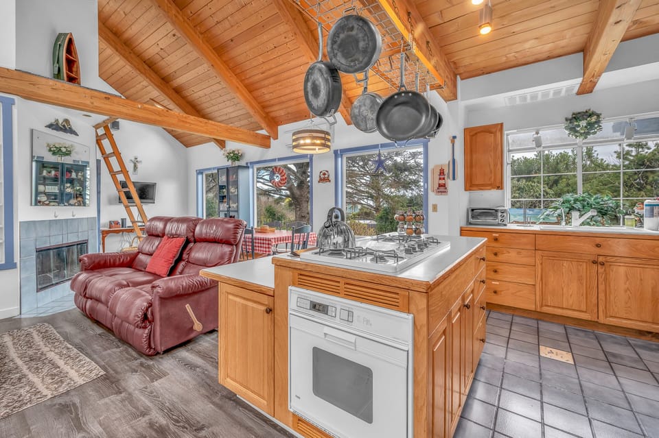 Settle into this spacious open-plan retreat where rustic wood beams meet modern comfort—your perfect cooking and relaxation sanctuary.