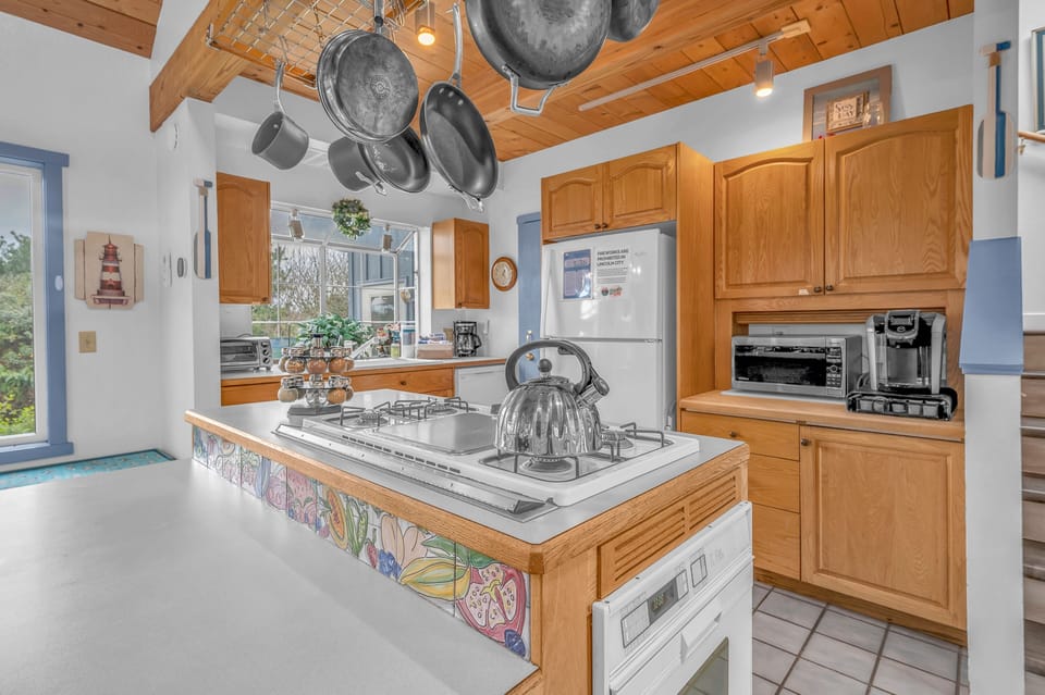 Your spacious kitchen awaits with warm wood cabinets, exposed beams, and everything you need to create memorable meals together.
