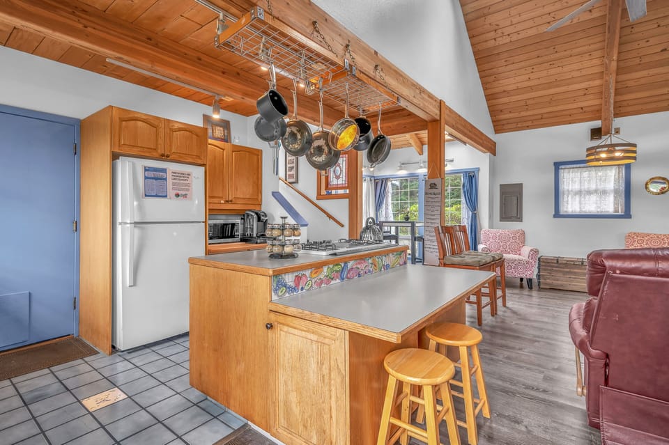 Your fully-equipped kitchen features warm wood cabinetry, professional cookware, and a cozy breakfast bar where you'll love cooking and gathering.
