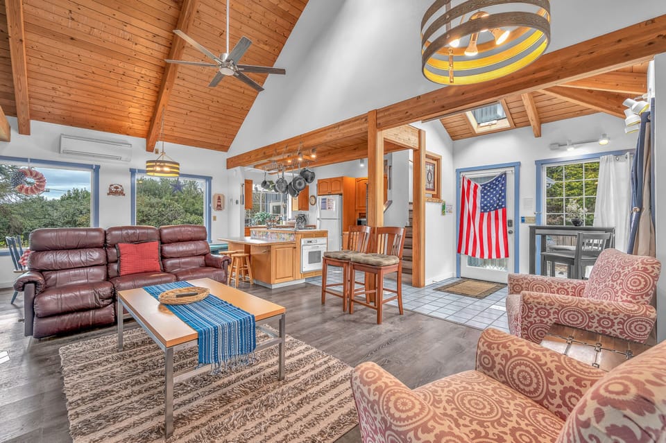 Relax in your spacious open-concept living space with soaring wood beams, comfortable seating, and a fully equipped kitchen perfect for gathering.