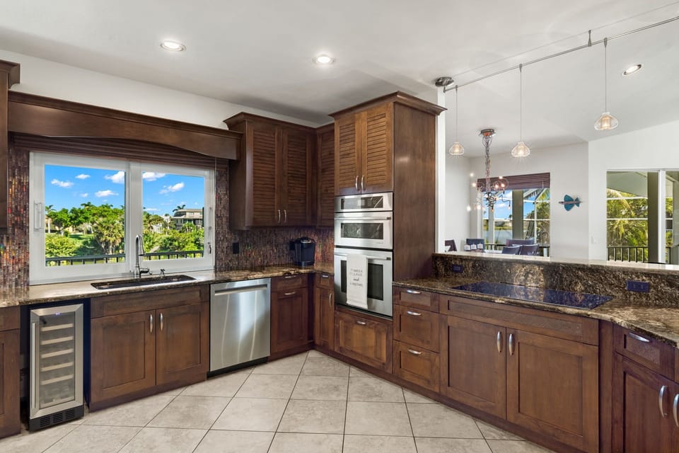 Large kitchen stocked with all kitchen appliances and a wine cooler.