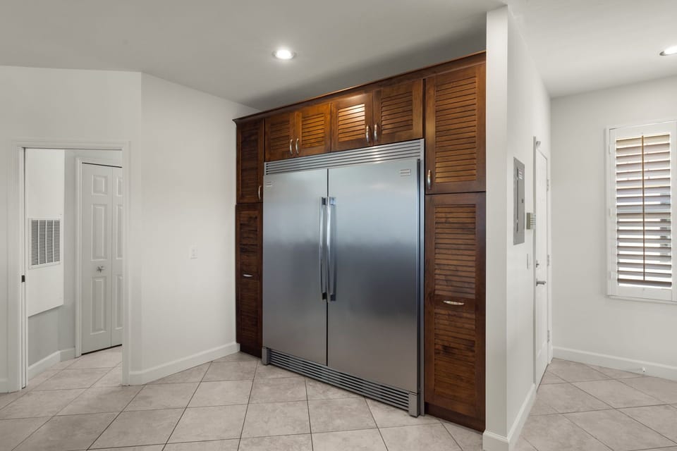 Extra large refrigerator/freezer with plenty of storage around it.