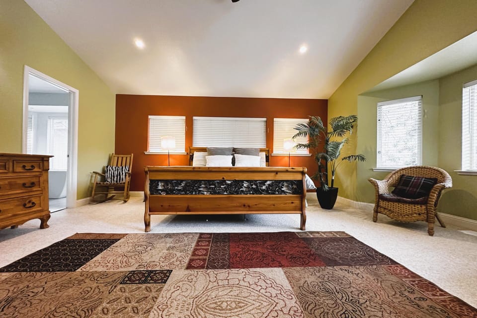 Spacious bedroom retreat with warm natural light and cozy seating