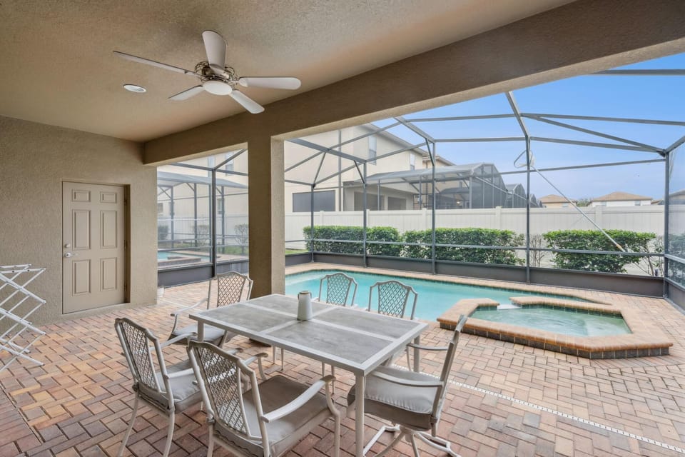 Covered patio dining overlooking a sparkling pool and spa