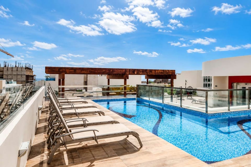 Shared rooftop pool with sun loungers and sea views
