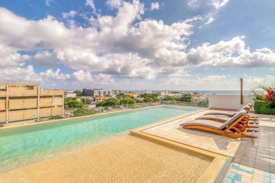 Shared rooftop pool with shaded daybed
