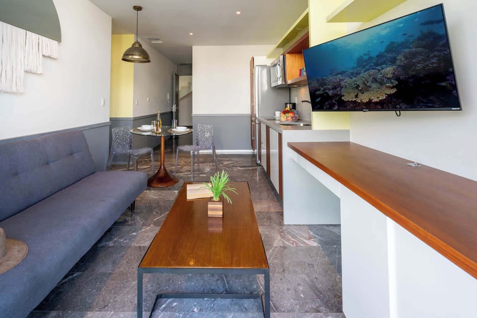 Bright living area with a comfy sofa and wall-mounted TV, easy relaxed evenings after a day at the beach