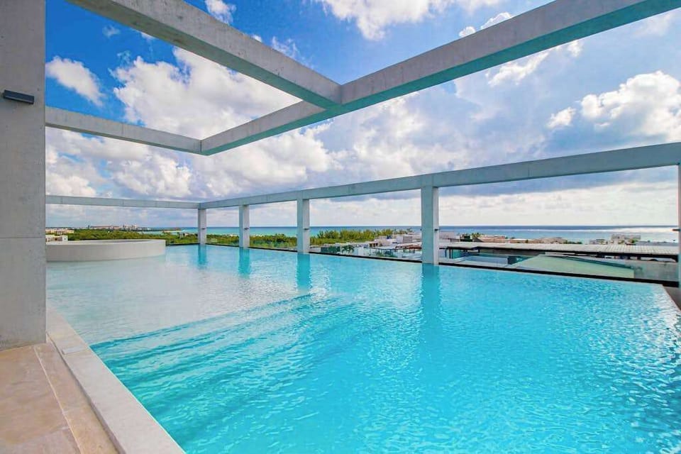 Shared rooftop infinity pool with loungers