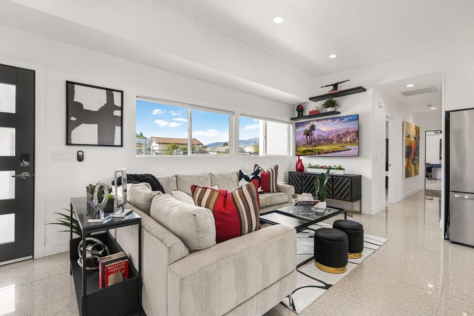 Spacious living room with TV, designer decor, and seating