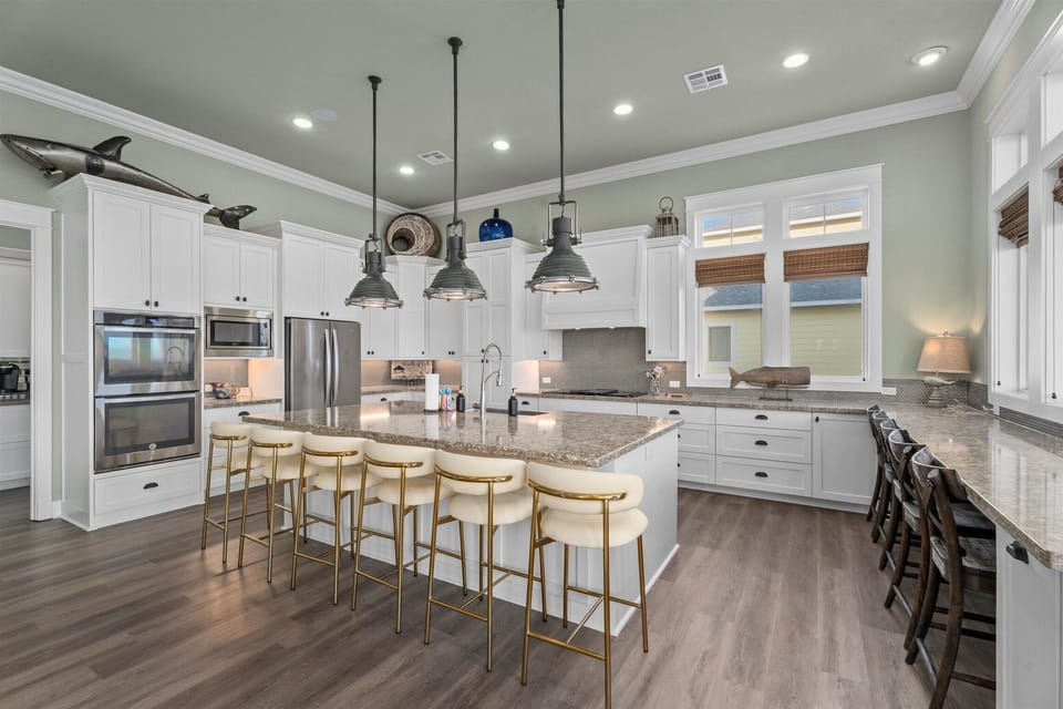 Modern kitchen with island, pendant lighting, and stainless appliances – fully equipped beachfront home