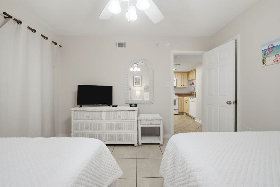 Ocean Breeze E702- Unwind in this bright, airy bedroom with coastal-inspired décor, crisp white linens, and your own TV—perfectly positioned for relaxation after a day of exploring.