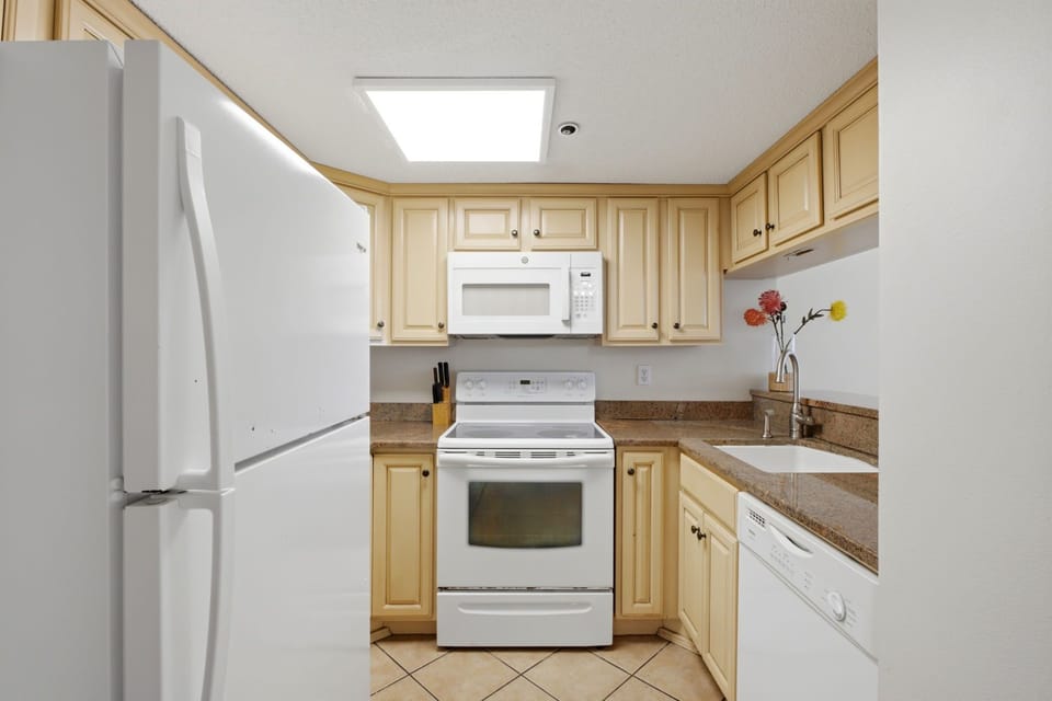Ocean Breeze E702- Your fully equipped kitchen features modern appliances, warm cabinetry, and a bright skylight—everything you need to prepare meals in comfort during your stay.