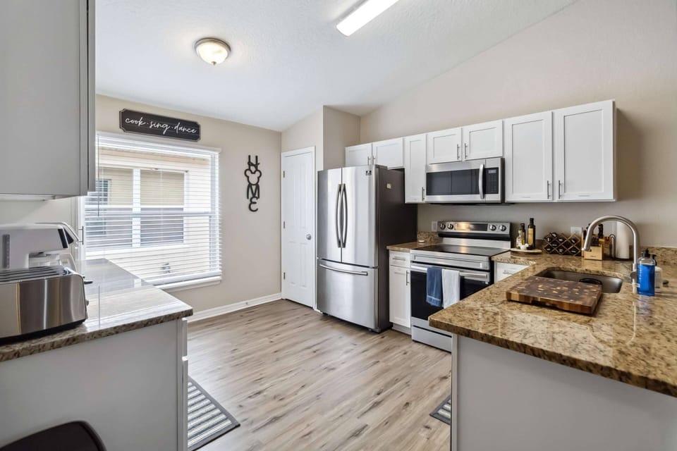 Bright and fully equipped kitchen with granite counters and stainless steel appliances