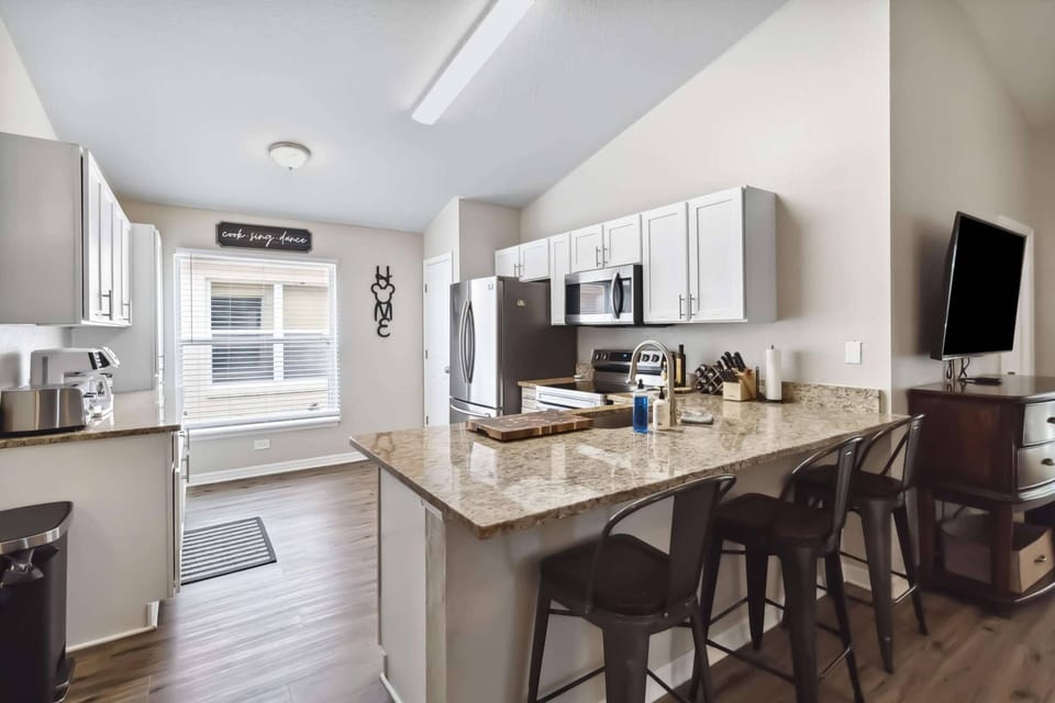 Bright and fully equipped kitchen with granite counters and stainless steel appliances