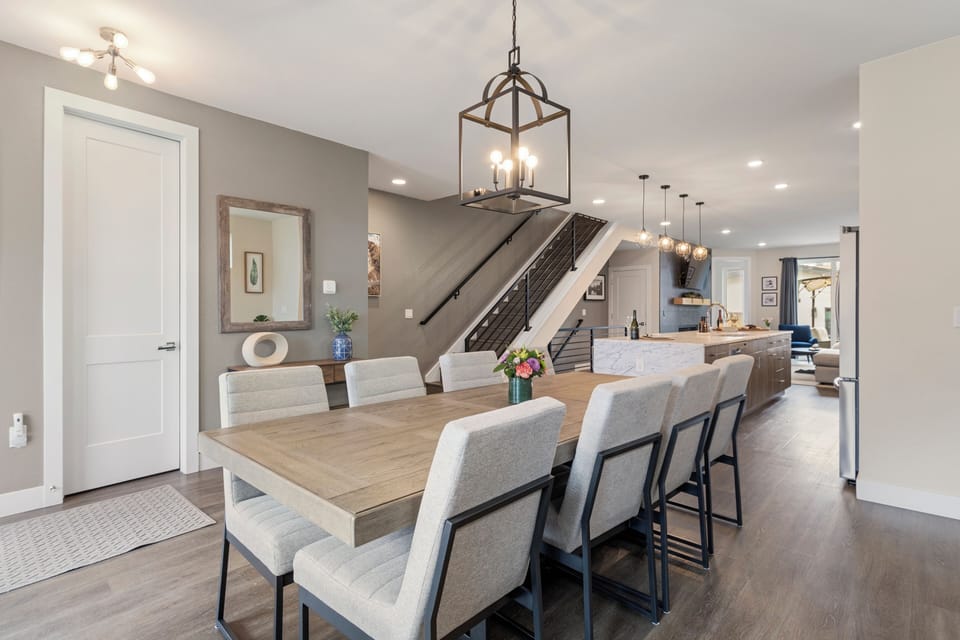 Gather around this spacious dining table where warm lighting and modern elegance create the perfect setting for memorable meals together.