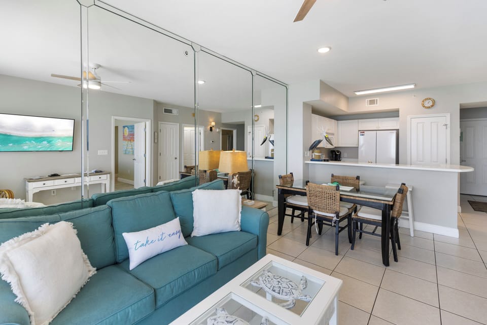 Sink into your cozy teal sofa while the open layout flows seamlessly from living to dining to kitchen—perfect for gathering together.