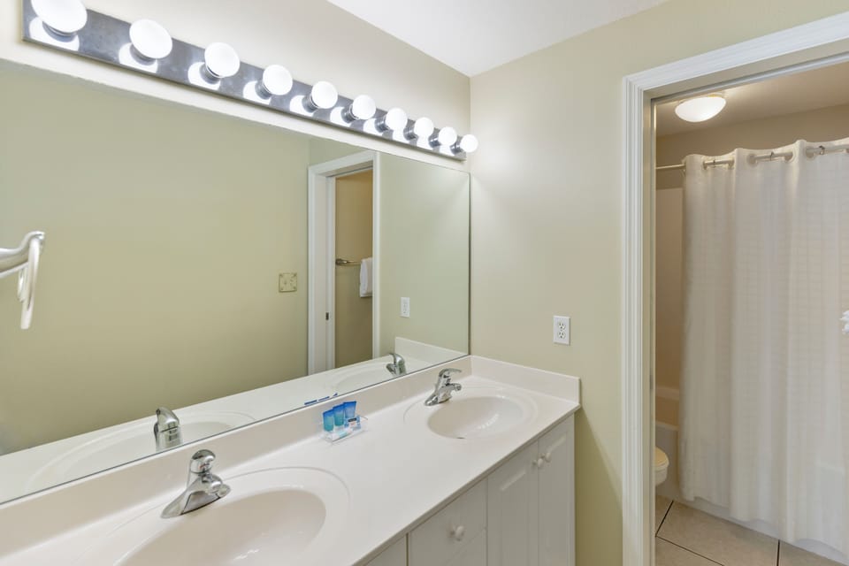 Step into your bright, spacious bathroom featuring dual vanities with Hollywood-style lighting and a refreshing shower to start your day.