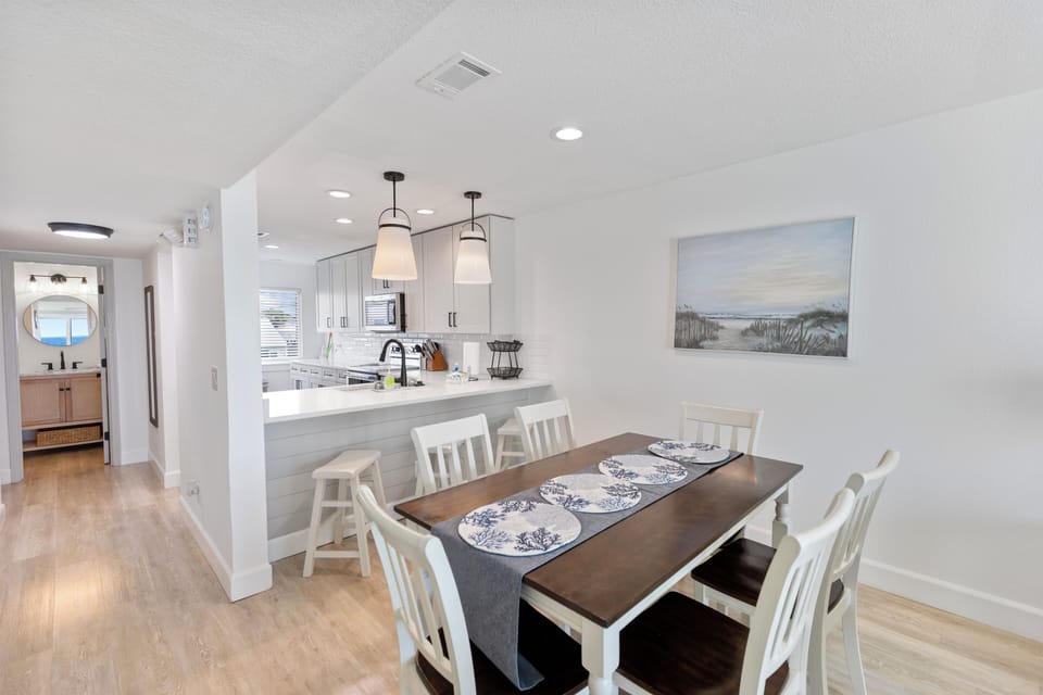 Your bright, open dining and kitchen area features coastal charm with pendant lighting, quartz counters, and a breakfast bar—perfect for family meals and morning coffee together.