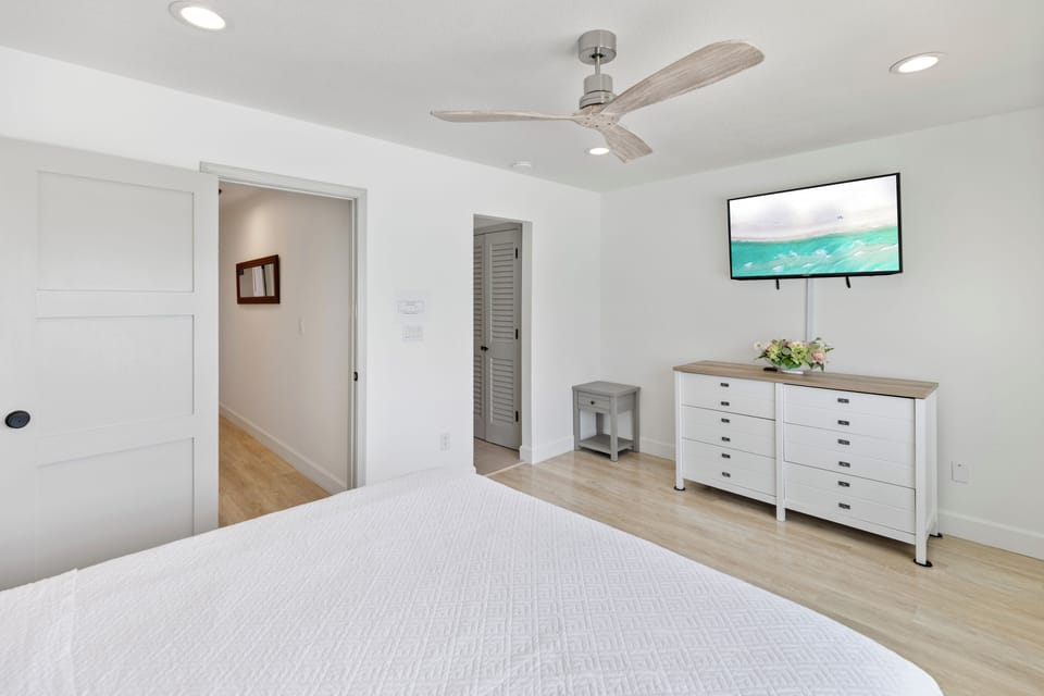 Relax in your bright, airy bedroom with a ceiling fan, plush bed, smart TV, and coastal artwork to set the mood for your getaway.